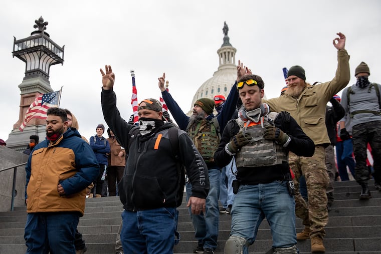 Members of the Proud Boys make a hand gesture while walking near the U.S. Capitol on Jan. 6, 2021.