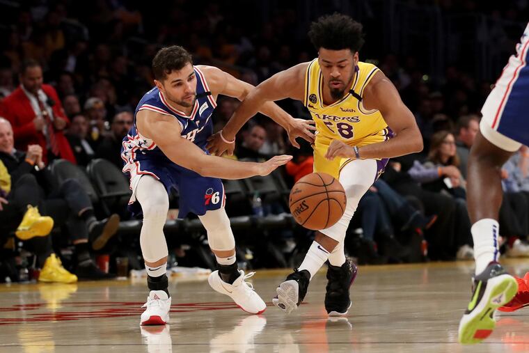 The Los Angeles Lakers' Quinn Cook (28) loses control of the ball against Raul Neto, left, during the second half of Tuesday's game at the Staples Center.