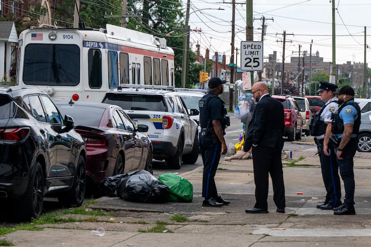 Detectives and police officers remain on the scene Sunday at Elmwood Avenue and South 73rd Streets after the fatal shooting of an off-duty Philadelphia police officer.