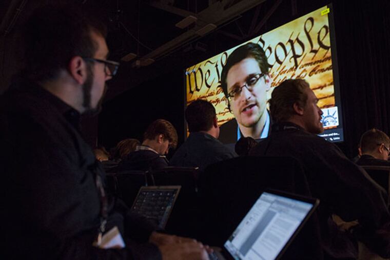 Attendees listen as Edward Snowden, the former National Security Agency contractor, speaks on screen during a virtual conversation at a featured session at the South By Southwest (SXSW) Interactive Festival in Austin, Texas, U.S., on Monday, March 10, 2014. The SXSW conferences and festivals converge original music, independent films, and emerging technologies while fostering creative and professional growth. (David Paul Morris/Bloomberg)