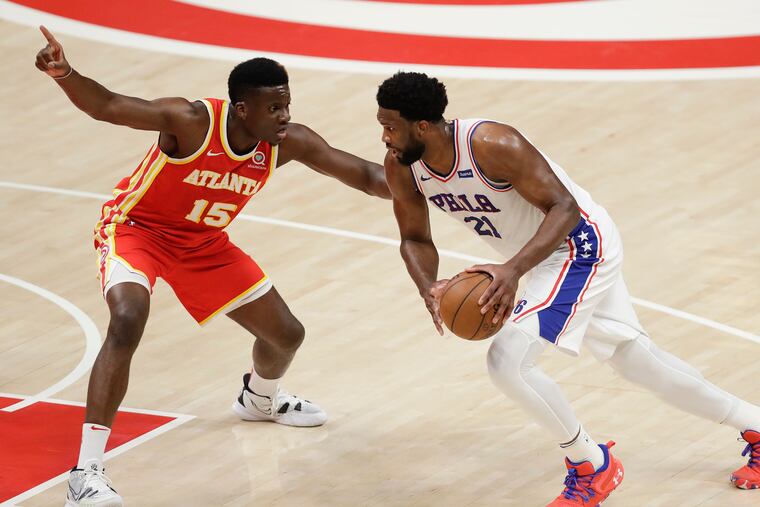 Sixers center Joel Embiid dribbles the basketball against Atlanta Hawks center Clint Capela in Game 3 of the NBA Eastern Conference playoff semifinals on Friday, June 11, 2021 in Atlanta.