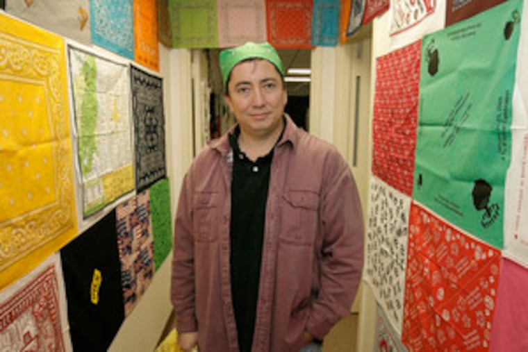 Daniel Weaver, at his warehouse in Hainesport, is flanked by samples of the bandanas that are a big part of his business.