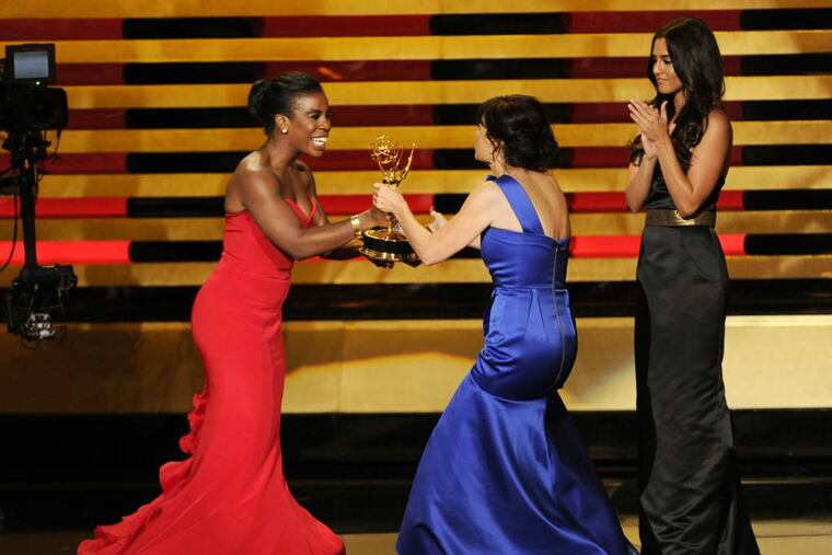 Uzo Aduba, left, presents the award for outstanding directing for a comedy series to Gail Mancuso for her work on “Modern Family� at the 66th Annual Primetime Emmy Awards at the Nokia Theatre L.A. Live on Monday, Aug. 25, 2014, in Los Angeles. (Photo by Chris Pizzello/Invision/AP)