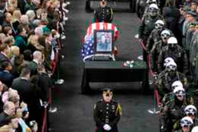 Relatives and law enforcement officials pay their respectsto (from front) Officers Stephen Mayhle, Paul Sciullo II,and Eric Kelly at the City-County Building in Pittsburgh.