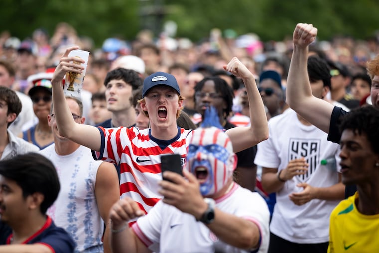 Cam Gorman, 23, of Gilbertsville, Montgomery County, cheers with Philly Sports Guy at the FIFA Fan Festival on June 19 as the USA beats Australia.