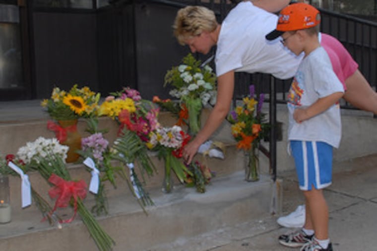 Patti Boyer of Kutztown and son Jacob, 5, lay flowers on the steps where police found Kyle Quinn.
