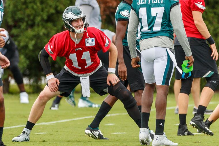 Eagles quarterback Carson Wentz, center, shares a light moment with receiver Alshon Jeffery, right, during warm ups prior to the Eagles practice at the NovaCare Center on Wednesday September 13, 2018. MICHAEL BRYANT / Staff Photographer