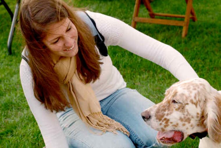Susquehanna University student Katie Leader enjoys a moment with Charlie, an English setter. Faculty took their dogs to school on Tuesdays in September to help freshmen adjust.
