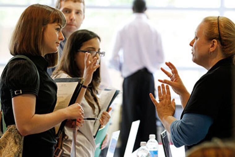 Erica Anselmo, right, from Independence Blue Cross, talks with Ashley Munz, a recent graduate of Franklin and Marshall at the Campus Philly job fair at Temple University last month. (Laurence Kesterson / Staff Photographer)