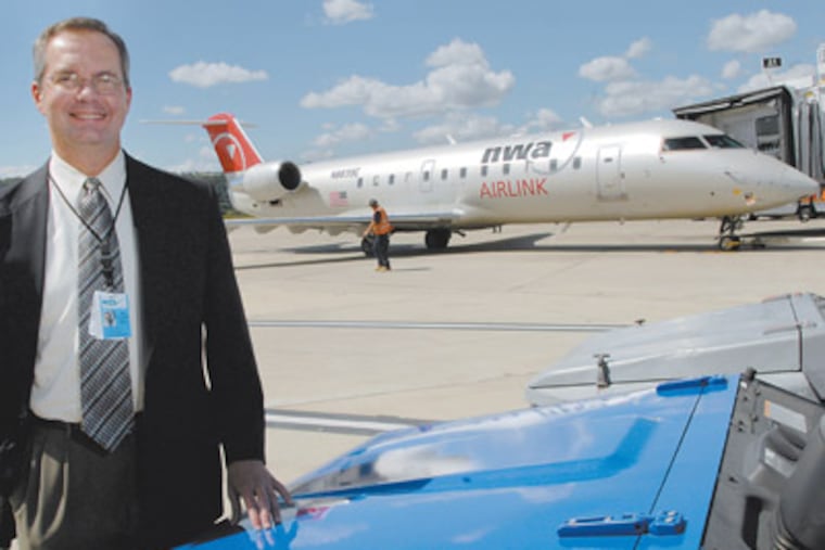 Harrisburg International Airport Executive Director Timothy Edwards stands in front of a Northwest Airlines 50 seat jet. (Jonathan Wilson/Inquirer) AIRPORTS14P A 105264 9/10/08 Harrisburg International Airport One Terminal Drive Middletown, PA. Photos are of the airport, Executive Director Timothy Edwards and American Airlines Ticketing Agent Beth Hudson.