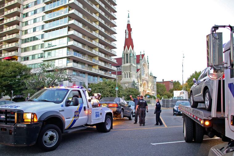 Police and Parking Authority trucks tow cars from Pennsylvania Avenue near 25th Street in the Fairmount section of Philadelphia. (For the Inquirer and Daily News/ Joseph Kaczmarek)