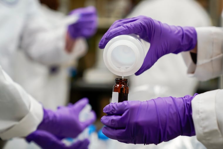Eva Stebel, water researcher, pours a water sample into a smaller glass container for experimentation as part of drinking water and PFAS research at the U.S. Environmental Protection Agency Center For Environmental Solutions and Emergency Response in 2023 in Cincinnati.