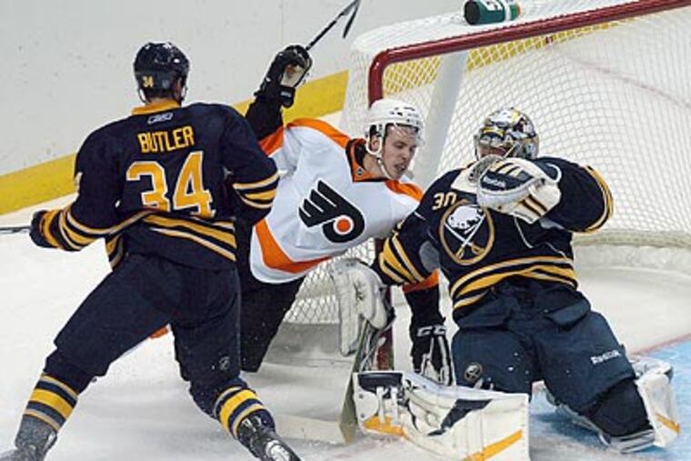 Sabres' Chris Butler (34) gets tangled up with Jon Kalinski in front of Buffalo Sabres goalie Ryan Miller. (AP Photo/Dan Cappellazzo)