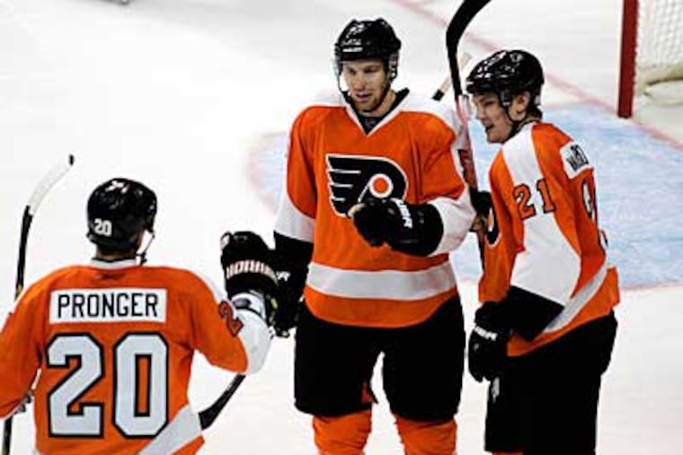 Chris Pronger (left), Braydon Coburn (center) and James van Riemsdyk celebrate one of Coburn's two goals in a 6-1 win over the Hurricanes earlier this season. (AP Photo / Tom Mihalek)