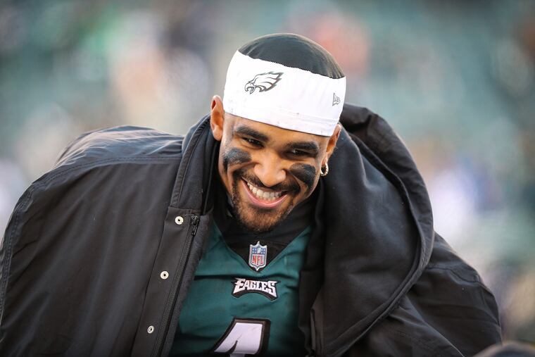 Eagles quarterback Jalen Hurts talks with his teammates late in the fourth quarter Sunday.