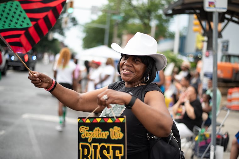 Rashida Ali waves a flag at the ninth annual Philadelphia Juneteenth Parade in West Philadelphia on Sunday, June 22, 2025. On June 19, 1865, more than 250,000 enslaved Americans were emancipated by Union soldiers, many of whom were Black and trained in the Philadelphia region, at the end of the American Civil War