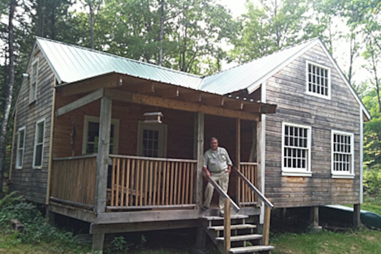 Lou Ureneck at the cabin he built in western Maine. Ureneck, a former Inquirer editor, took to the woods to pursue a dream in his late 50s, a time when "life's losses begin to pile up."