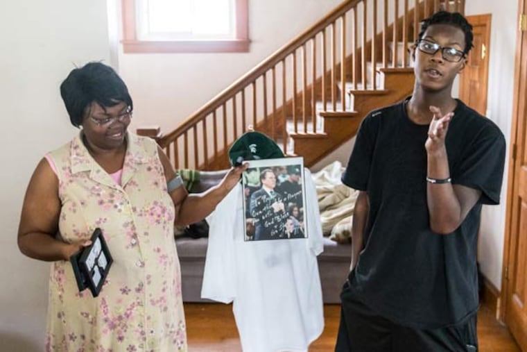 Tasha Jetson holds an autographed photo from Michigan State Coach Tom Izzo while Ryan Brown discusses talking with the coach via the phone and offering him player advice on July 15, 2015 in Hammond, Ind. (Jim Karczewski/Post-Tribune/TNS)