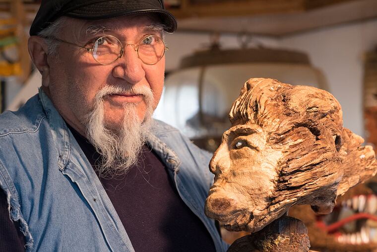 Pinelands folk folk artist Josiah "Josh" Westcott with a sculpture of an old man he fashioned out of a piece of wood.