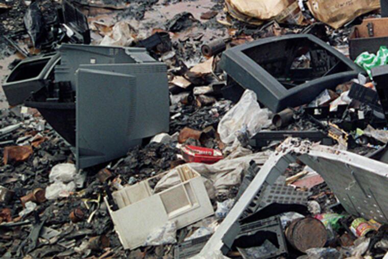 Discarded computers and other electronics are thrown into a landfill with other waste. E-waste poses health and environmental problems. (Bill Lambrecht/St. Louis Post-Dispatch/MCT)