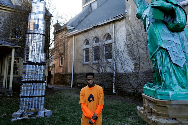 Artist Kambel Smith poses with his sculptures of the Burj Khalifa and the Statue of Liberty at the Germantown Historical Society.