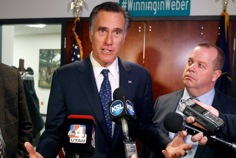 FILE - In this Friday Jan., 18, 2019 file photo, Utah Sen. Mitt Romney, left, speaks with reporters in Ogden, Utah.