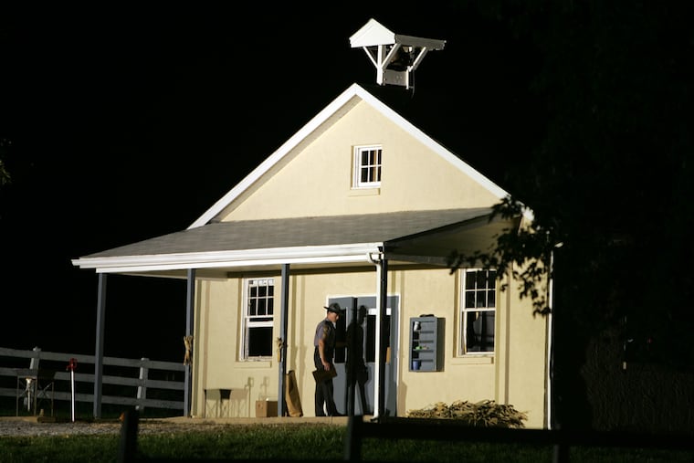 A state trooper closes the front doors of Nickel Mines School, where a gunman killed several people and injured others in Nickel Mines, Pa., on Oct. 2, 2006. Eighteen years later, shooting survivor Rosanna King has died.