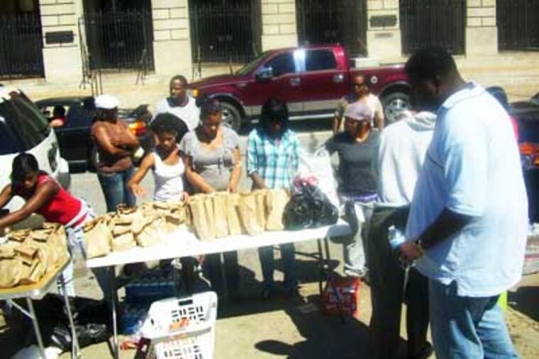 Craig Stroman (right) and other volunteers feed the homeless on Vine Street outside the Free Library. (Photo provided by Craig Stroman)