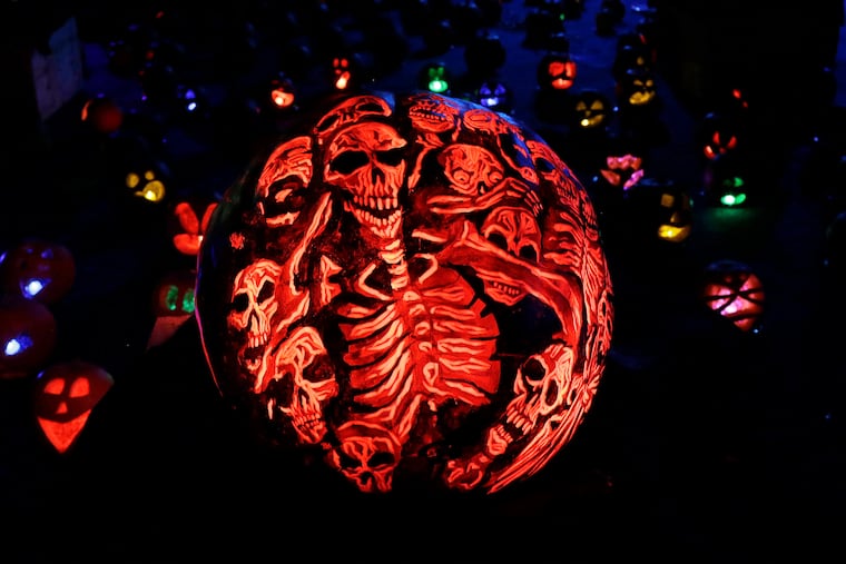 A pumpkin carved and painted with skeletons is displayed at the Rise of the Jack O'Lanterns Show in 2016 in Boston.