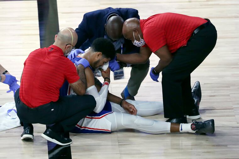 Aug 23, 2020; Lake Buena Vista, Florida, USA; Philadelphia 76ers forward Tobias Harris (12) is attended to after hitting his head against the Boston Celtics during the third quarter in game four of an NBA basketball first-round playoff series at The Field House. Mandatory Credit: Kim Klement-USA TODAY Sports