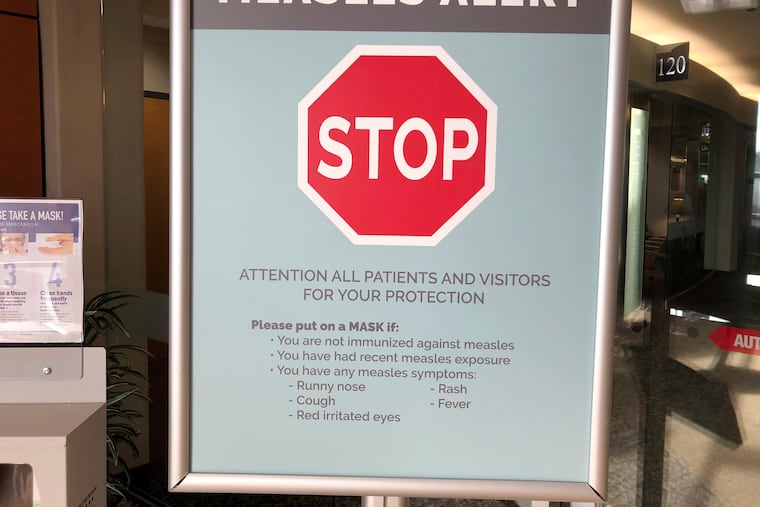 In this Jan. 30, 2019 photo, signs posted at The Vancouver Clinic in Vancouver, Wash., warn patients and visitors of a measles outbreak.