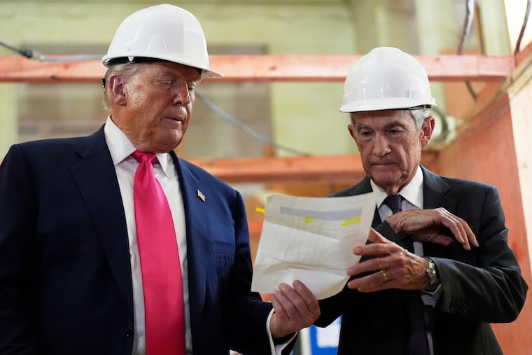 FILE - Federal Reserve Chairman Jerome Powell, right, and President Donald Trump look over a document of cost figures during a visit to the Federal Reserve, Thursday, July 24, 2025, in Washington.