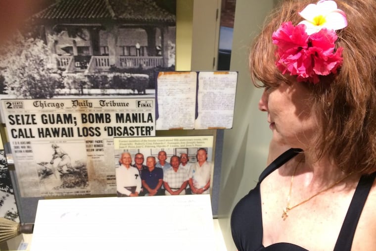 In 2014 in Guam, Stu Bykofsky’s girlfriend, “Half-Pint,” looks at a newspaper in a museum display picturing her grandfather as a member of the Guam Insular Force Guard who survived World War II.