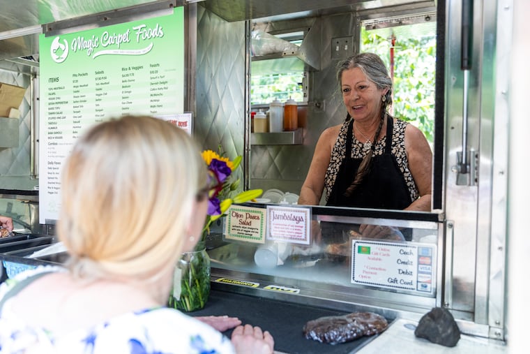 Deb Varvoutis, owner of Magic Carpet, makes a lunch order for a regular who brought her flowers.