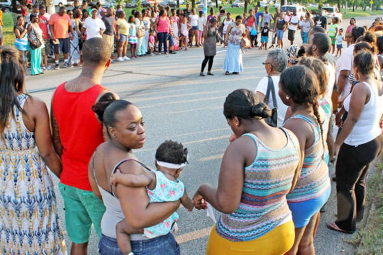 A crowd gathers at the location on the Boulevard where Samara Banks and three of her children were killed hours after the crash in July. (Courtney Marabella / Staff Photographer)