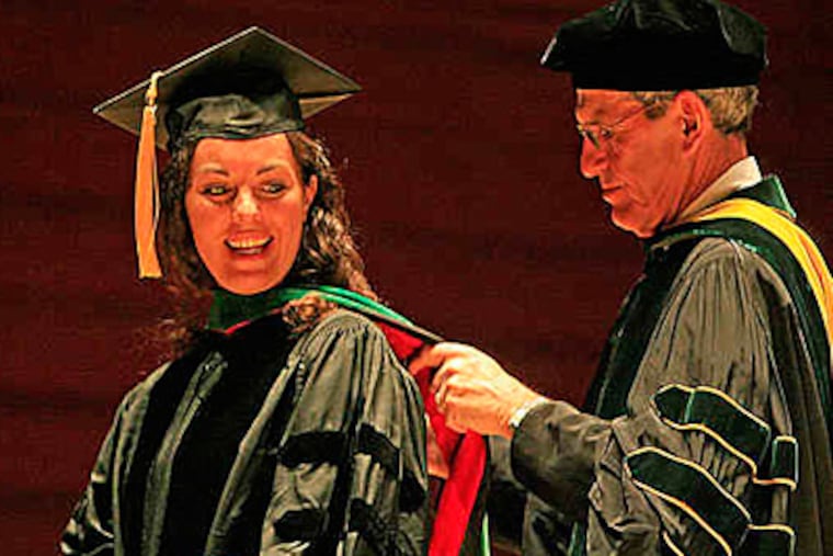 Aura Obando receives her academic hood from associate dean Stanley Goldfarb.