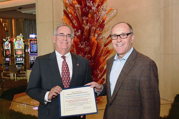 Division of Gaming Enforcement Director David Rebuck (L) and Borgata President and Chief Operating Officer Tom Ballance (R) hold an Internet Gaming Permit. Borgata in Atlantic City has received the first Internet Gaming Permit in the history of New Jersey from the Division of Gaming Enforcement. The casino plans to be the first to launch I-gaming from servers from its casino on Nov. 26. (Courtesy photo)