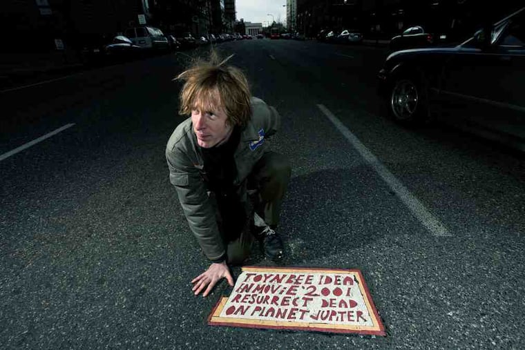 Justin Duerr with a Toynbee tile in a scene from "Resurrect Dead: The Mystery of the Toynbee Tiles." Duerr has been probing the case for years.