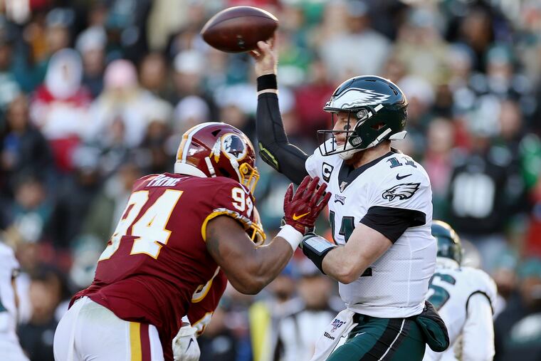 Eagles quarterback Carson Wentz throws a pass under pressure from Washington Redskins defensive lineman Daron Payne during the third quarter. Payne ended up hitting Wentz and getting flagged for roughing the passer.