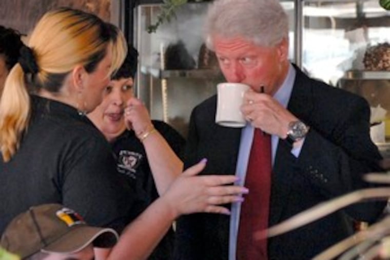 Bill Clinton sips coffee and chats with server Susan Borman (left) at the Penrose Diner while campaigning for his wife, presidential candidate Hillary Rodham Clinton.