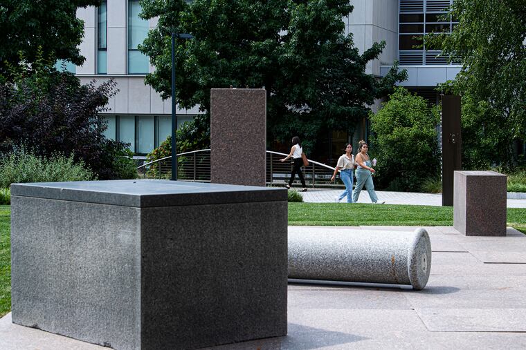 People walk on Wednesday near the "Monument in Waiting," Theaster Gates' sculptural installation on the campus of Drexel University