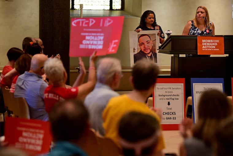 Rosalind Pichardo (left) co-founder of Operation Save Our City, holds a photo of murder victim Alejandro "Alex" Rojas-Garcia, as his mother, Aleida Garcia (right), founder of the National Homicide Justice Alliance speaks at the Philadelphia Episcopal Cathedral August 18, 2019, during a rally hosted by Moms Demand Action for Gun Sense in America.