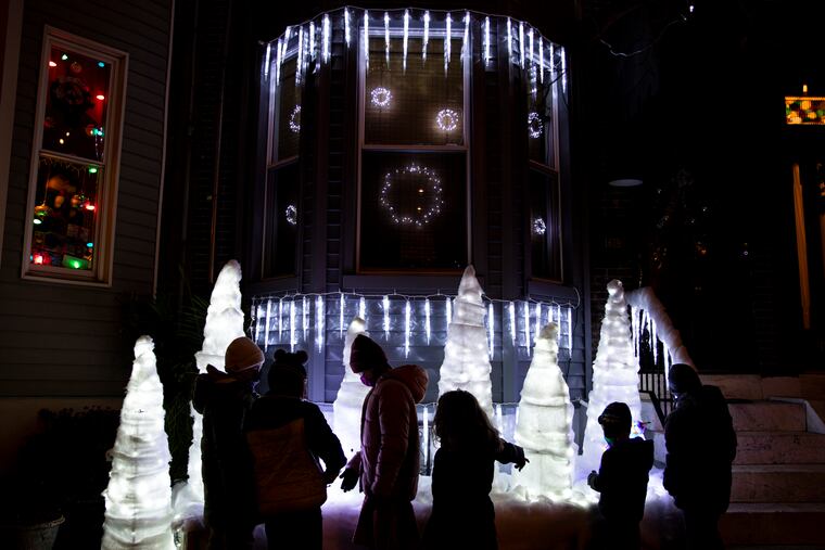 Kids look at the Christmas lights and decorations at the Miracle on South 13th Street block party in 2021.