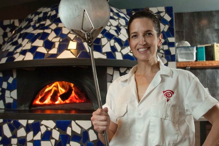 Stephanie Reitano, owner/chef of Capofitto, by her wood-fired pizza oven, which reaches 900 degrees and cooks a pizza in 90 seconds.