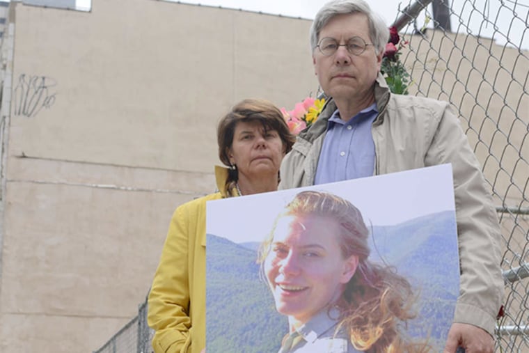 Jay Bryan and Nancy Winkler hold a photo of daughter Anne, killed with five others in last June's collapse at 22d and Market. An early plan to turn the site into a parking lot left them "horrified."
