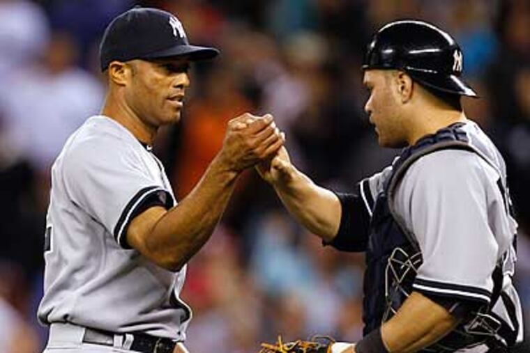 Mariano Rivera is congratulated by Russell Martin after closing out his 600th career game. (Elaine Thompson/AP)