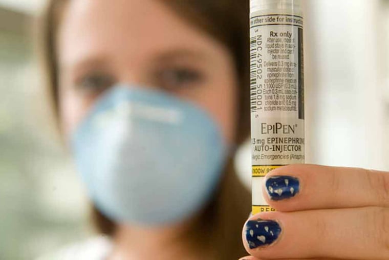 A high school student with severe nut allergies, displays an EpiPen.
