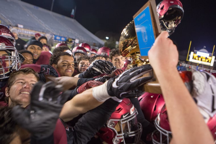 Players for St. Joseph's Prep hold the trophy high after winning the PIAA Class 6A football championship in December. The Hawks will be defending their title this season.