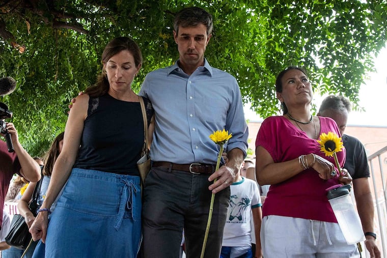 Democratic presidential candidate Beto O'Rourke walks next to his wife Amy Hoover Sanders and US Rep. Veronica Escobar during a silent march holding sunflowers in honor to the victims of a mass shooting occurred in Walmart on Satuday morning in El Paso on Sunday, August 4, 2019.