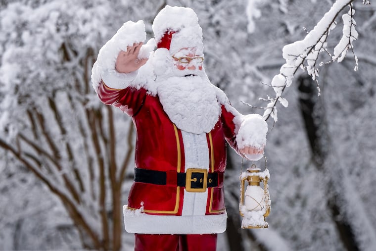 A Santa statue “waves” to drivers along Brace Road in Cherry Hill Sunday morning.
